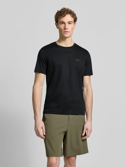 Männermodel trägt Regular Fit T-Shirt aus reiner Baumwolle Modell 'PS Spirit 70 Grx' von BOSS Green X PORSCHE, unifarben, Ganzkörperansicht von vorne.