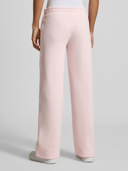 Frauenmodel trägt Wide Fit Sweatpants aus Baumwoll-Mix von REVIEW in Rosa, mit elastischem Bund und Bordüre, Ganzkörperansicht Rückansicht.