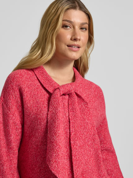 Frauenmodel trägt Strickpullover aus Wolle mit Schluppe von Christian Berg Woman, Two-Tone-Optik in Pink, Nahaufnahme Oberkörper.