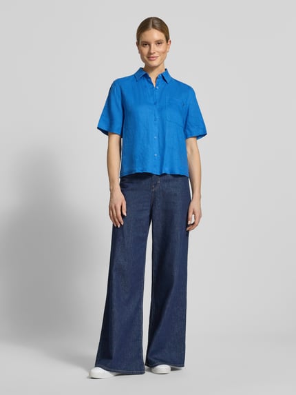 Frauenmodel trägt Loose Fit Leinenbluse mit Brusttasche von Tommy Hilfiger in Blau, Optik: Unifarben, Kurzarm, reines Leinen, Ganzkörperansicht von vorne.