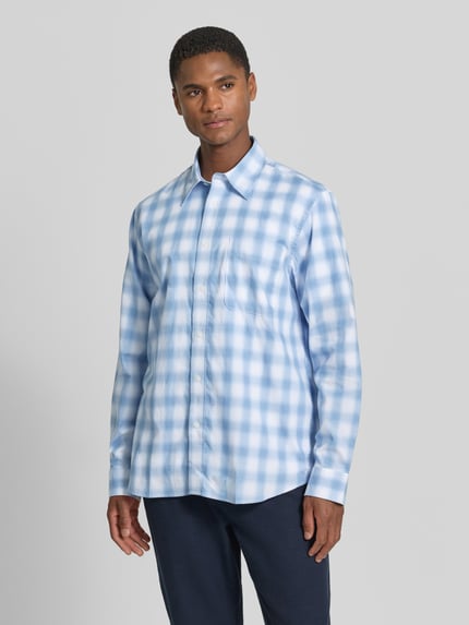 Männermodel trägt Regular Fit Freizeithemd aus reiner Baumwolle Modell 'BOB' von SELECTED HOMME im hellblau karierten Muster, Ganzkörperansicht von vorne.