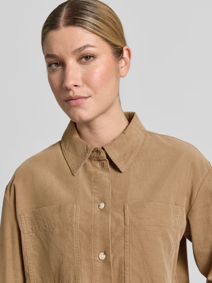 Frauenmodel trägt Regular Fit Langarmbluse aus reiner Baumwolle Modell 'Fronna' von OPUS in Beige mit sichtbarer Struktur, Nahaufnahme Oberkörper, Damen Langarmbluse von OPUS.