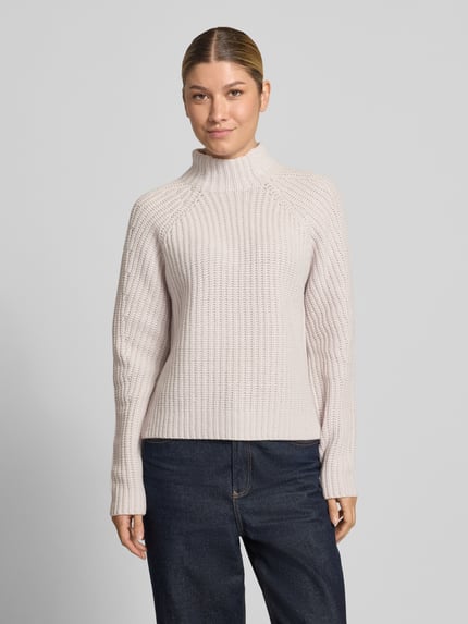 Frauenmodel trägt Strickpullover aus Kaschmir-Baumwoll-Mix Modell 'LONA' von 0039 Italy in Creme, grobe Strickstruktur, Ganzkörperansicht von vorne. Regular Fit, Stehkragen, Rückenlänge 60 cm, Ärmellänge 78 cm.