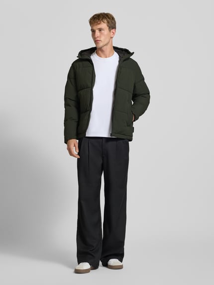 Männermodel trägt Steppjacke mit Kapuze Modell 'GALAXY' von JACK & JONES in Dunkelgrün, Regular Fit, Ganzkörperansicht von vorne.