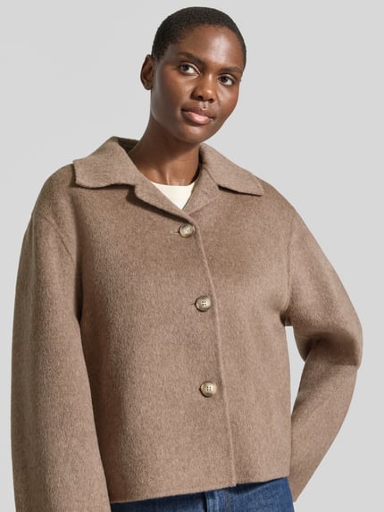 Frauenmodel trägt Regular Fit Jacke aus Woll-Mix von Jake*s Collection in Hellbraun mit großen Knöpfen, Nahaufnahme Oberkörper.