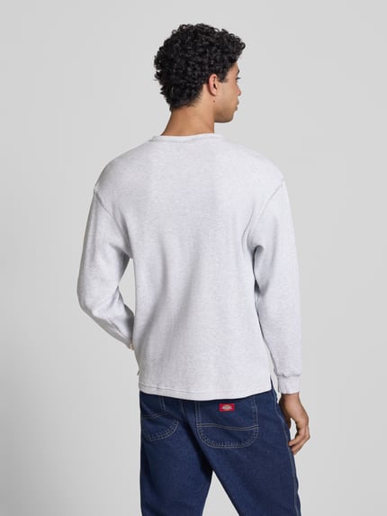 Männermodel trägt Longsleeve mit Logo-Stitching von BLKVIS, Reine Baumwolle, Loose-Fit, Strukturmuster, Rundhalsausschnitt, Rückenlänge 75 cm, Ganzkörperansicht Rückansicht.