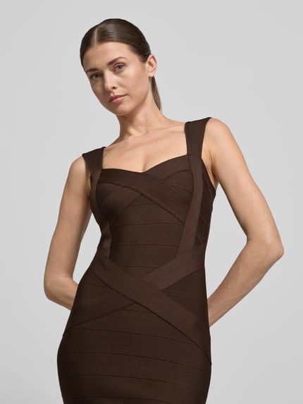 Vrouwenmodel draagt Slim Fit jurk in mouwloos design van Lipsy, elastische materiaalmix, structuurpatroon, ritssluiting, bruine tinten, detailopname bovenlichaam.