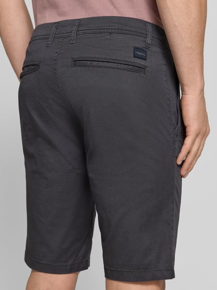 Männermodel trägt Slim Fit Chinoshorts aus Baumwoll-Mix von Tom Tailor, Optik:Allover-Muster, feines Webmuster, Twill, Ganzkörperansicht Rückansicht.