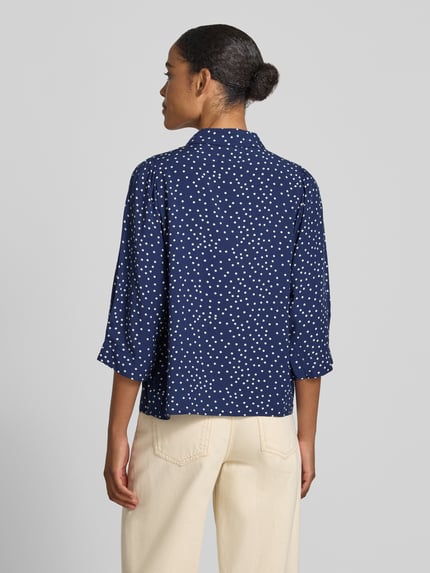 Frauenmodel trägt Regular Fit Bluse aus Viskose mit 3/4-Arm Modell 'Bono' von LOLLYS LAUNDRY in Dunkelblau mit weißem Allover-Look, Hemdblusenkragen und Knopfleiste, Rückenlänge 60 cm, Ärmellänge 45 cm, Ganzkörperansicht Rückansicht.