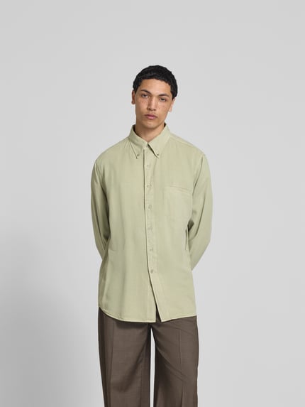 Męski model nosi Freizeithemd aus reinem Lyocell od Filippa K, jasny zielony, krój relaxed fit, kieszeń na piersi, kołnierzyk button-down, długie rękawy, długość tyłu w rozmiarze 50: 72 cm, szerokość w rozmiarze 50: 48 cm, długość rękawa w rozmiarze 50: 70 cm, gładka tekstura, widok całej sylwetki z przodu.