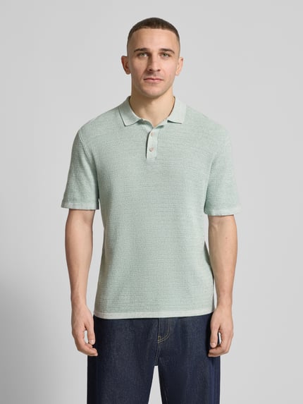 Männermodel trägt Regular Fit Poloshirt mit Strukturmuster Modell 'GEORGE' von Jack & Jones aus Baumwoll-Mix, Ganzkörperansicht von vorne.