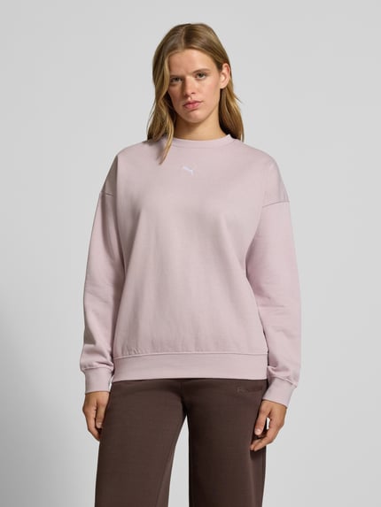 Kobiece model nosi Oversized Sweatshirt aus Baumwoll-Mix Modell 'ESS OVERSIZED' od PUMA, damska bluza, jasnoróżowy kolor, gładka tekstura, Ganzkörperansicht von vorne.