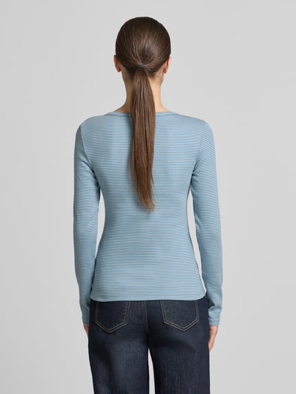 Frauenmodel trägt Regular Fit Langarmshirt mit Henley-Ausschnitt von Tom Tailor Denim, bawełniany mix, niebieski, gładka faktura, krój regular fit, widok całej sylwetki z tyłu
