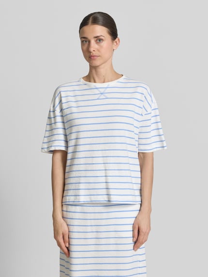 Vrouwenmodel draagt Regular Fit T-Shirt met ronde hals van Smith and Soul, wit met blauwe strepen, puur katoen, schouderdetails, vooraanzicht bovenlichaam.