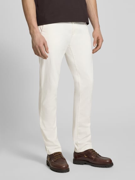 Męski model nosi Slim Fit Chino aus Baumwoll-Mix Modell 'Chino Slim' von BOSS Orange, efekt: jednolity kolor, krój slim fit, naszywka z logo, szlufki na pasek, zapięcie na guzik i ukryty zamek błyskawiczny, wpuszczane kieszenie boczne, kieszenie z tyłu, wykończenie materiału: splot twill, mieszanka bawełny, Ganzkörperansicht z przodu.