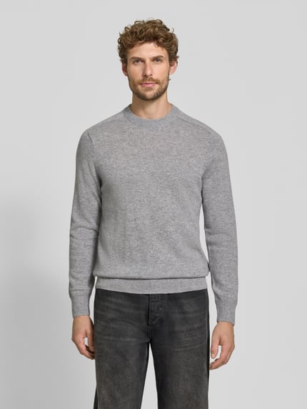 Männermodel trägt Regular Fit Strickpullover aus reinem Kaschmir von FTC Cashmere in Grau, glatte Textur, Ganzkörperansicht von vorne.