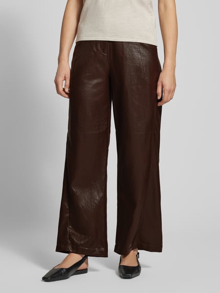 Frauenmodel trägt Wide Leg Kunstlederhose mit Gürtelschlaufen von Jake*s Casual in dunklem Braun mit glatter Oberfläche, Ganzkörperansicht von vorne.