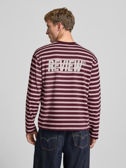 Männermodel trägt Gestreiftes Langarmshirt mit Logoprint vorne und hinten von REVIEW, Baumwolle, Regular Fit, Rückenlänge M 61 cm, Ganzkörperansicht Rückansicht
