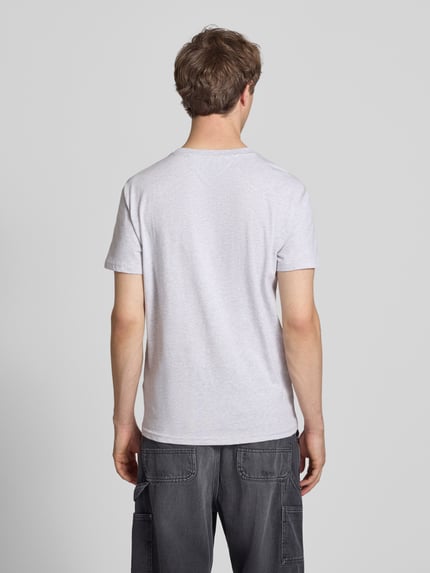 Männermodel trägt Regular Fit T-Shirt aus reiner Baumwolle von Tommy Jeans, unifarben, kurzarm, Rundhals, Ganzkörperansicht Rückansicht.