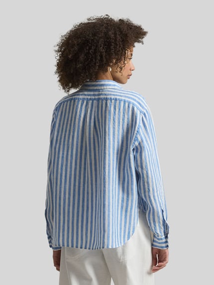 Frauenmodel trägt Boxy Fit Hemdbluse aus reinem Leinen von Polo Ralph Lauren mit blauen und weißen Streifen, Rückenpasse, Ganzkörperansicht Rückansicht.