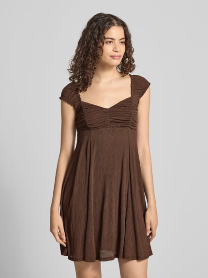 Frauenmodel trägt ausgestelltes Freizeitkleid mit Strukturmuster Modell 'HELDA' von ONLY in Braun, Damen Freizeitkleid, Nahaufnahme Oberkörper.