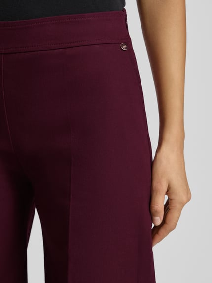 Vrouwenmodel draagt Hose mit elastischem Bund und Eingrifftaschen van Rinascimento in bordeauxrood, katoenmix met stretch, wijde pijp, detailopname rechterheup.