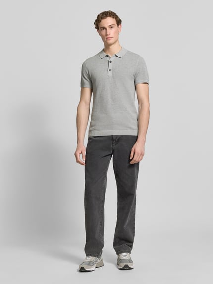 Männermodel trägt Regular Fit Poloshirt aus reiner Baumwolle von s.Oliver RED LABEL, Optik: Unifarben, Strickoptik, Ganzkörperansicht von vorne.
