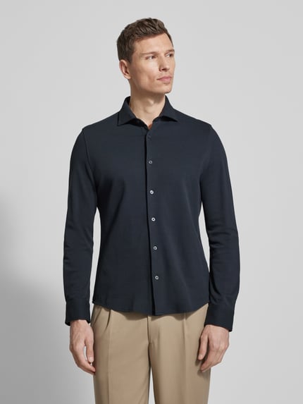 Männermodel trägt Shaped Fit Freizeithemd aus reiner Baumwolle von Marc O'Polo, unifarben, Cutaway-Kragen, Piquétextur, Ganzkörperansicht von vorne.