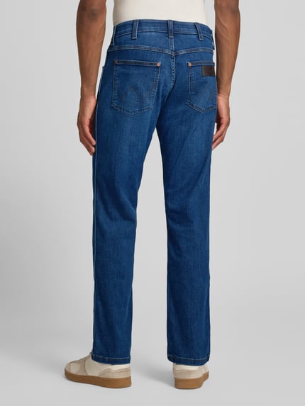 Männermodel trägt Straight Fit Jeans im 5-Pocket-Design Modell 'Greensboro' von Wrangler, katoenmix met stretch, achteraanzicht volledige lengte.