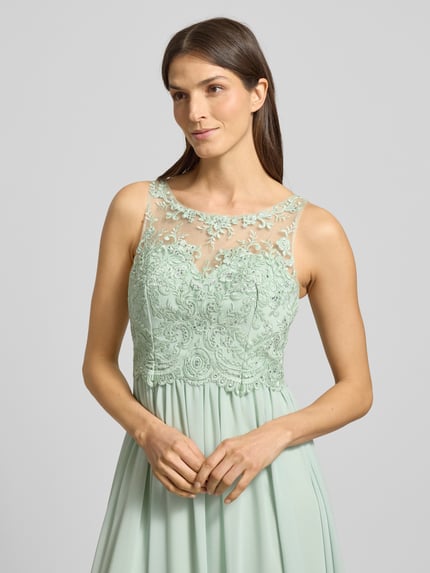 Frauenmodel trägt Regular Fit Abendkleid mit floralem Spitzenbesatz von Laona, semitransparentes Design, Nahaufnahme Oberkörper.