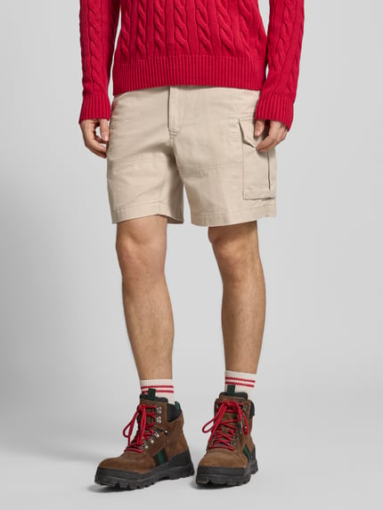 Męski model nosi Relaxed Fit Cargoshorts aus reiner Baumwolle von Polo Ralph Lauren, efekt: jednolity kolor, krój relaxed fit, wyhaftowane logo, szlufki na pasek, zapięcie na guzik i zamek błyskawiczny, wpuszczane kieszenie boczne, kieszenie z tyłu na guzik, kieszenie cargo, tkana faktura, bawełna, Ganzkörperansicht von vorne.