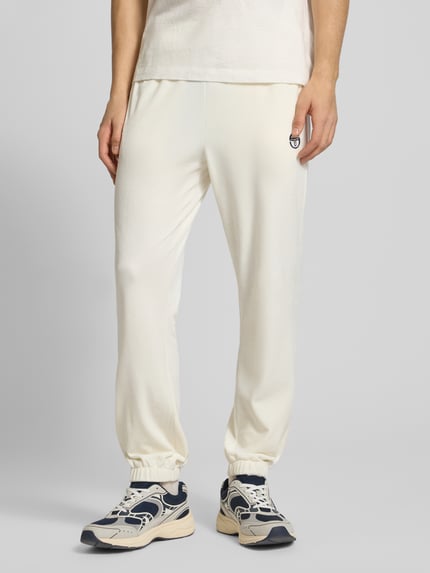 Männermodel trägt Sweatpants mit elastischem Bund von SERGIO TACCHINI, weiß, Material-Mix mit Stretch-Anteil, Lockerer-Schnitt, Ganzkörperansicht von vorne.