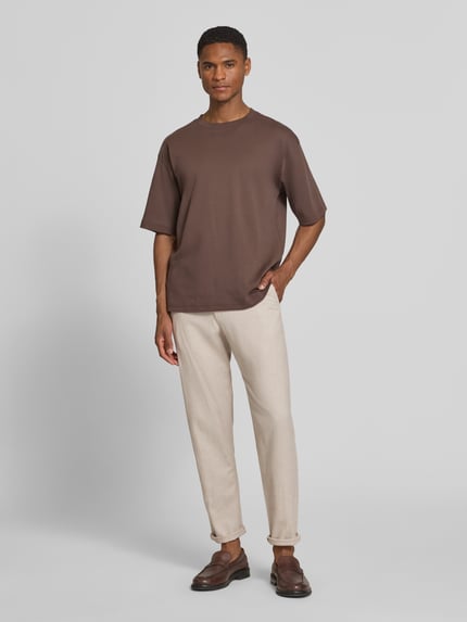 Männermodel trägt Regular Fit Stoffhose aus Baumwoll-Leinen-Mix von SELECTED HOMME in Melange-Optik, helle Webware, Ganzkörperansicht von vorne.