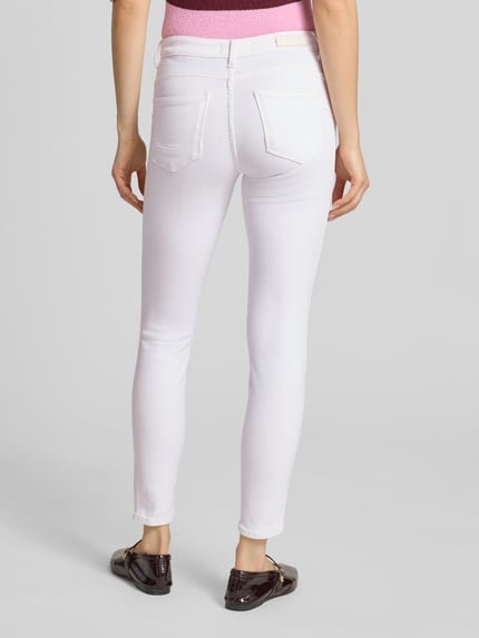 Frauenmodel trägt Skinny Fit Jeans aus Baumwoll-Mix Modell 'POWER' von Only in Optik: Unifarben, Materialverarbeitung: Stretch-Webstruktur, 5-Pocket-Design, Label Patch, Farbe Weiß, Ganzkörperansicht Rückansicht.