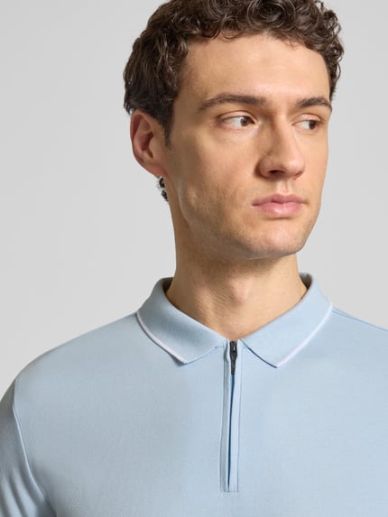 Männermodel trägt Regular Fit Poloshirt mit Baumwoll-Anteil von HECHTER PARIS in Hellblau, Reißverschluss, elastische Ärmel, Nahaufnahme Oberkörper.