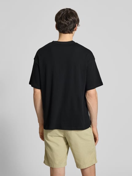 Männermodel trägt T-Shirt mit Label-Print und Rundhalsausschnitt von Jack & Jones, Reine Baumwolle, Regular-Fit, Rückenlänge 68 cm, Ganzkörperansicht Rückansicht.