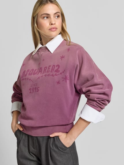 Vrouwenmodel draagt Sweatshirt met Labelprint van Dsquared2 in paars, puur katoen, los model, ronde hals, elastische boorden, ruglengte maat XS 61 cm, voorkant close-up.