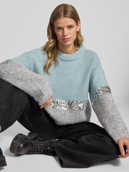 Frauenmodel trägt Relaxed Fit Strickpullover mit Woll-Anteil Modell 'MAINE' von Only in Two-Tone-Optik, Paillettenbesatz, Strick, Nahaufnahme Oberkörper.