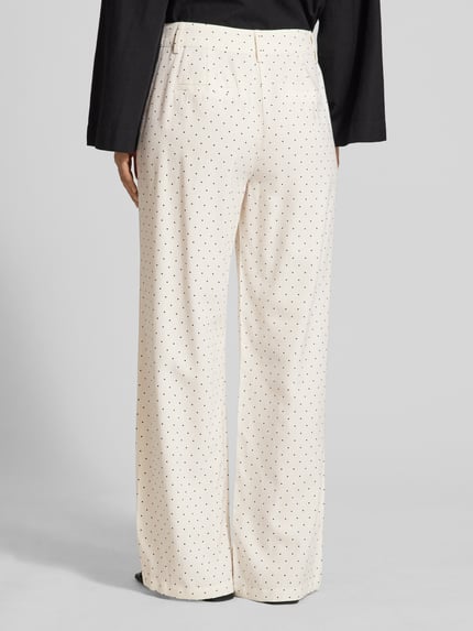 Frauenmodel trägt Wide-Leg-Pants aus Viskose-Mix mit Eingrifftaschen von FREE/QUENT in Creme mit schwarzen Punkten, Leinen-Viskose-Mix, Gesäßleistentaschen, Modell Anya, Ganzkörperansicht Rückansicht.