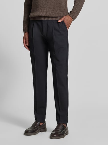Männermodel trägt Tapered Fit Weite Hose 'MOROT JOGGER' - Marc O'Polo × DFB Travel Collection in Schwarz, Herren Weite Hose von Marc O'Polo, Nahaufnahme Unterkörper.