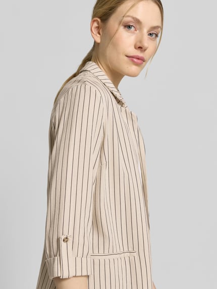 Kobiece model nosi Loose Fit Kurzblazer aus Viskose-Leinen-Mix Modell 'JESMILO' od Vero Moda, tkanina flammgarn, kremowy w pionowe paski, luźny krój, rękawy 3/4 z mankietami, imitacja kieszeni, kołnierz z klapami, bez zapięcia, widok z przodu, zbliżenie na górną część ciała.