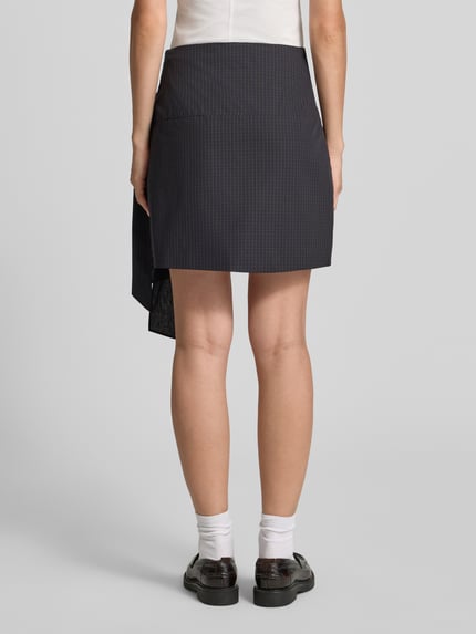 Frauenmodel trägt Körpernaher Mini-Rock aus reiner Baumwolle von Jake*s, feines Karomuster in Dunkelblau und Schwarz, Damen Mini-Rock von Jake*s Casual, Ganzkörperansicht Rückansicht.