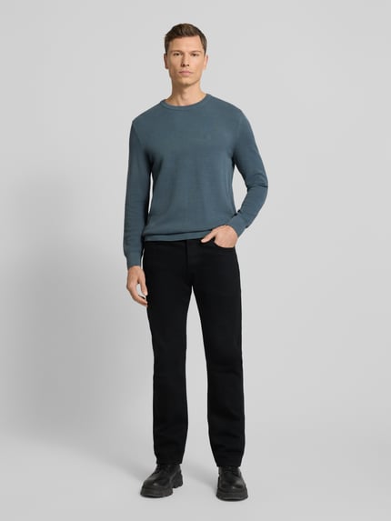 Męski model nosi Regular Fit Pullover aus reiner Baumwolle von Marc O'Polo, efekt: jednolity kolor, sweter z okrągłym dekoltem, krój regular fit, długi rękaw, zakończenie rękawów prążkowane, pikowane wykończenie, bawełna, Ganzkörperansicht von vorne.