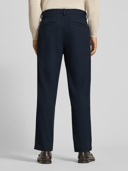 Männermodel trägt dunkelblaue Tapered Chino mit Woll-Anteil Modell 'Chino' von BOSS Orange, Webware, Rückansicht Ganzkörperansicht.