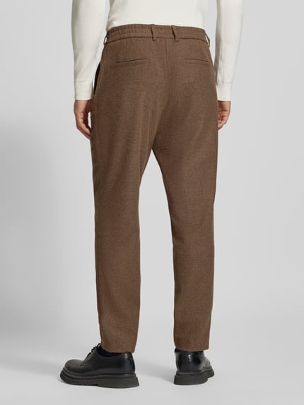 Männermodel trägt Regular Waist Business-Hose aus Wollmix von BOSS in Braun mit Tunnelzug, Gesäßtaschen, Ganzkörperansicht Rückansicht.