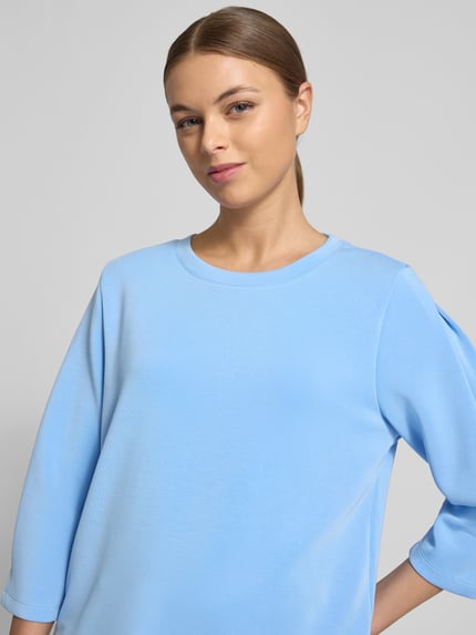 Frauenmodel trägt Comfort Fit Sweatshirt aus Modal-Mix von s.Oliver RED LABEL in Hellblau, unifarben, 3/4-Arm, Nahaufnahme Oberkörper.