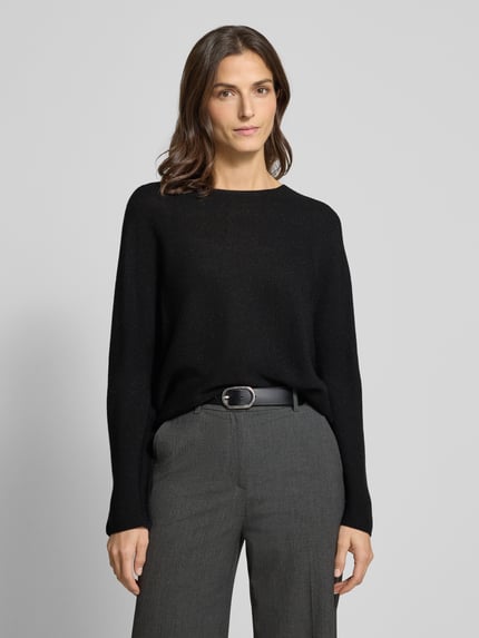 Frauenmodel trägt Schimmernder Strickpullover aus Woll-Mix von Rich & Royal in Schwarz, Regular Fit, Rundhalsausschnitt, Nahaufnahme Oberkörper.