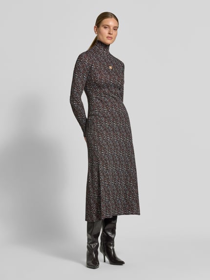 Frauenmodel trägt Maxikleid aus Viskose-Mix von Rabanne, dunkles Muster, Stehkragen, Cut-Out, figurbetont, Ganzkörperansicht von vorne.
