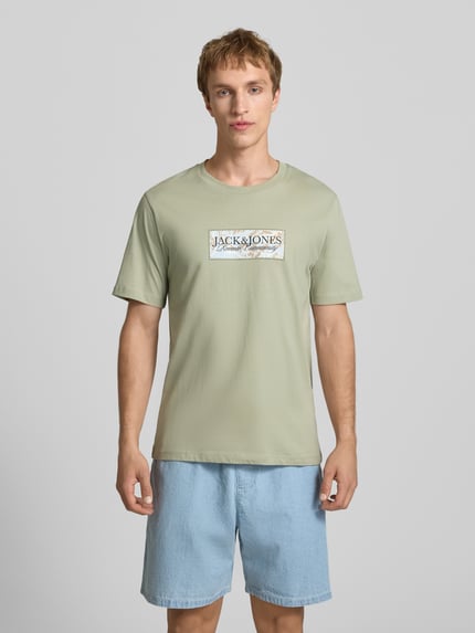 Männermodel trägt T-Shirt mit Label-Print von Jack & Jones in hellem Grün, Reine Baumwolle, Gerader-Schnitt, Rundhalsausschnitt, Ganzkörperansicht von vorne.