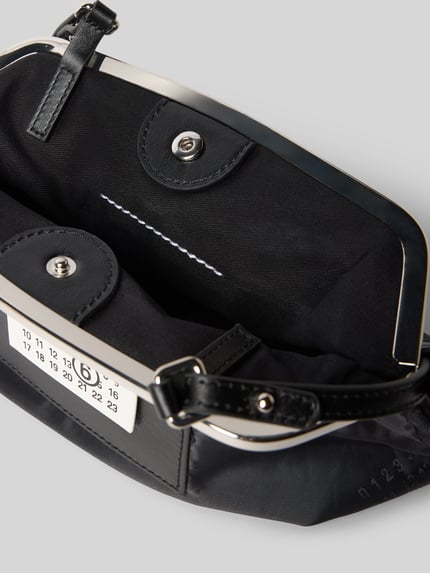Produktfoto, Pochette mit Magnetverschluss von MM6 Maison Margiela, czarna, gładka faktura, nadruk z motywem, naszywka z logo, główna przegroda, regulowany pasek na ramię, szerokość w rozmiarze 1: 25 cm, długość w rozmiarze 1: 20 cm, głębokość w rozmiarze 1: 9 cm